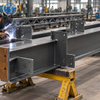 Workers welding a custom industrial equipment support frame in the fabrication workshop